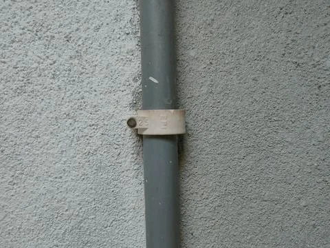 The image shows a PVC pipe with a pipe clip or saddle clamp.This type of cl.. Stock Photos