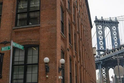 The image shows a red brick building with a street sign in front. The Manhatt Foto stock