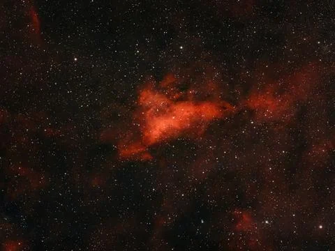 This image shows a red nebula with many stars in the vastness of space. Stock Photos