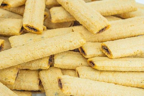 Image shows a stack of golden, textured rectangular biscuits or crackers, l.. Stock Photos