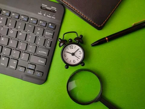This image shows a styled flat lay of office workspace items on a green bac.. Stock Photos