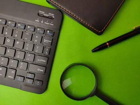 This image shows a styled flat lay of office workspace items on a green bac.. Stock Photos