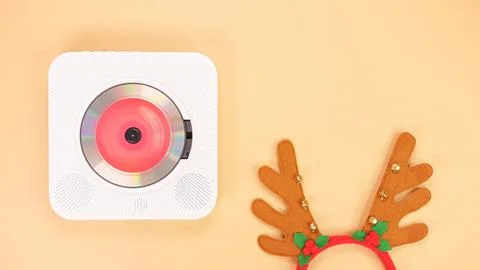 The image shows a white portable CD player with red headphones on a beige bac Stock Photos