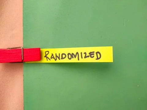 The image shows the word RANDOMIZED written in black marker on a yellow sli.. Stockfoto's