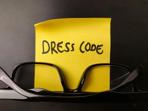 The image shows a yellow sticky note with the words DRESS CODE written on i.. Stock Photos