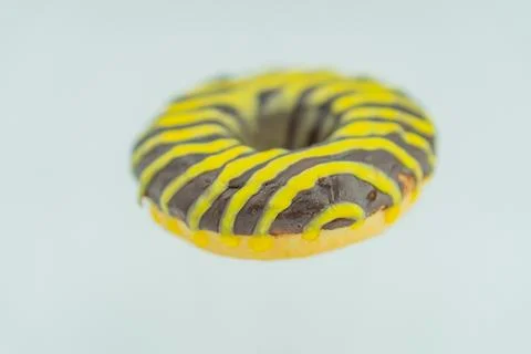 Image of a single, close-up doughnut with zigzag-patterned frosting yellow an Stock Photos