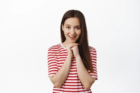 Image of smiling 20s girl looks hopeful and happy at camera, waiting for smth Stock Photos