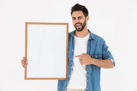 Image of smiling bearded man winking while holding and pointing finger at emp Foto stock