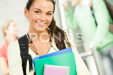 Image of smiling student holding books and looking at camera Stock Photos