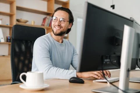 Image of smiling unshaven programmer man working with computer Stock Photos