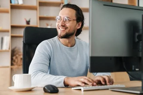Image of smiling unshaven programmer man working with computer Stock Photos