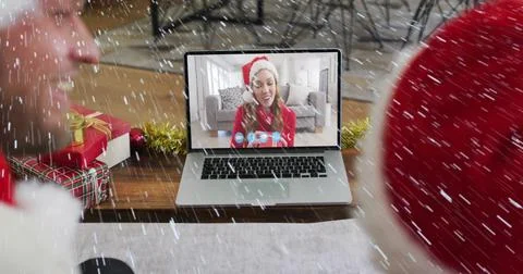 Image of snow falling over smiling couple in santa hats on laptop video call Ilustração Stock