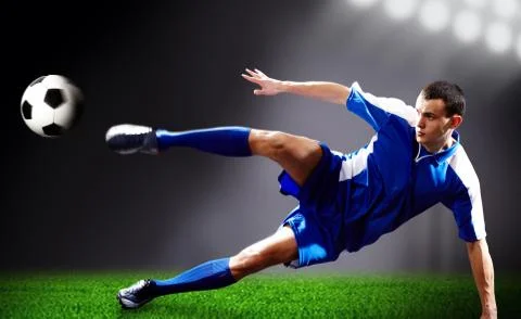 Image of soccer player doing flying kick with ball on football field Stock Photos