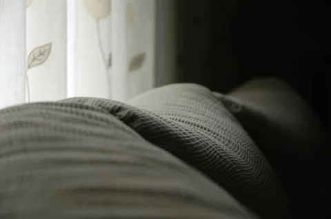 Image of a sofa cushions with a patterned curtain Stock Photos