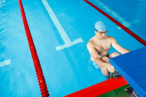 Image of sportive swimmer man in blue cap at side in pool Stock Photos