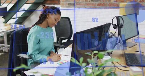 Image of statistical data processing against african american woman taking notes 库存照片