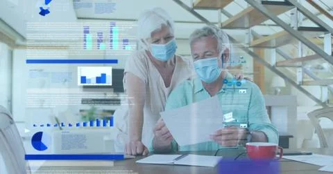 Image of statistical data processing over senior couple wearing face masks 库存照片