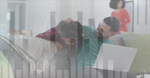 Image of statistics and data processing over man and son using laptop Foto stock