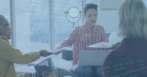 Image of stock market data processing over diverse colleagues passing a document Foto stock