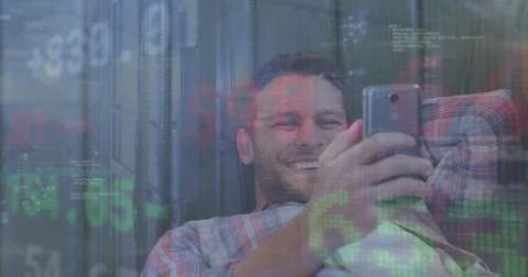 Image of stock market data processing over caucasian man smiling while using Stock Photos