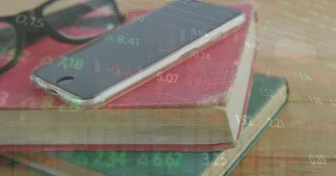 Image of stock market data processing over close up of books, smartphone and 写真素材