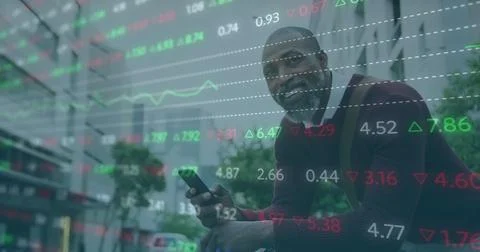 Image of stock market data processing over happy african american man using 写真素材