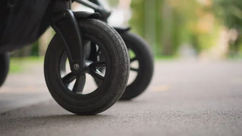 Image of stroller rolling on asphalt with safety features. Vivid closeup of Video stock 346382912