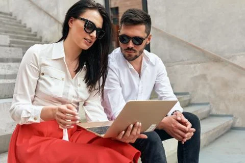 Image of stylish freelance people using technology for working outside. Coupl Stock Photos
