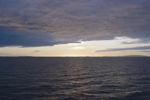 Image of the sunset hidden by clouds over the sea Stock Photos