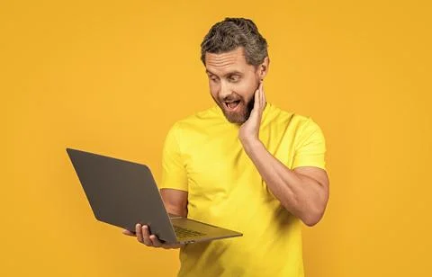 Image of surprised man programmer with laptop. man programmer isolated on yellow 스톡 사진
