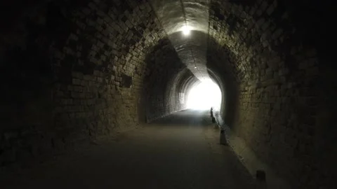 Image taken while walking in a tunnel that gradually sinks into the light. Stock Footage 136408668