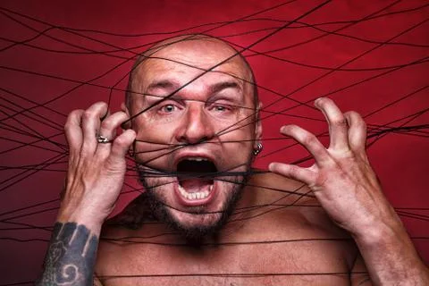 Image of tangled in black threads bald man Foto stock