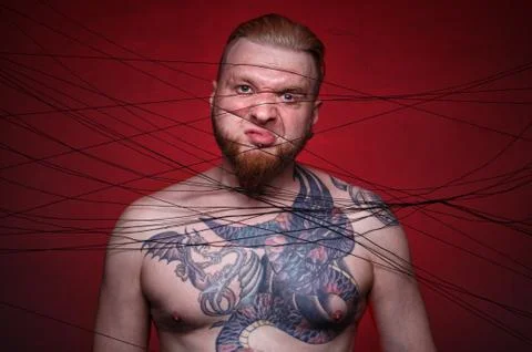Image of tangled in black threads bearded angry man Stock Photos