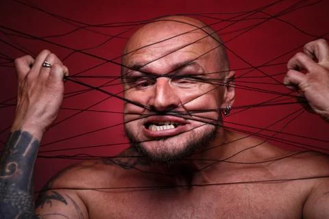 Image of tangled in threads bald man on red background Stock Photos