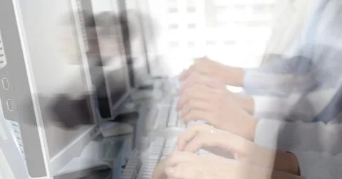 Image of team of colleagues typing on computer keyboards with people walking in Stock Photos
