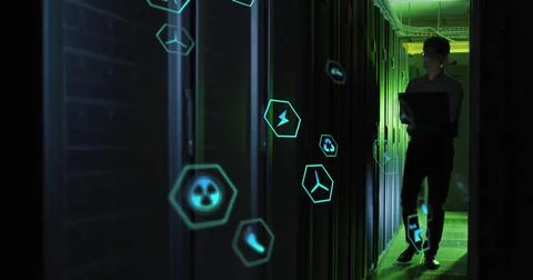Image of tech icons in hexagones over asian man working in server room Foto stock
