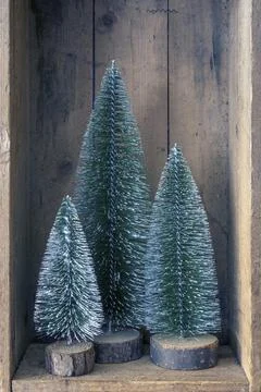 An image of three Christmas tree objects in a wooden box Stock Photos