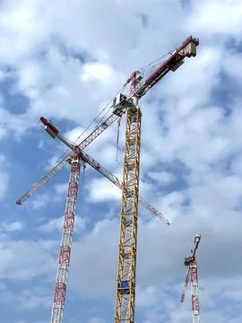 Image of three cranes working together on the construction site Stock Photos