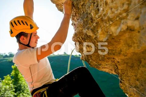 Image of tourist man in helmet clambering up Stock Photos
