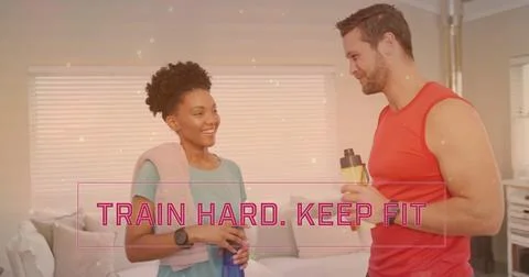 Image of train hard keep fit text over diverse couple drinking water at home Fotos Stock