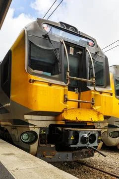 An image of a train sitting at a station platform. The platform is located in Stock Photos
