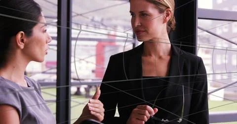 Image of tunnel in seamless pattern over two diverse businesswomen discussi.. Stock Photos
