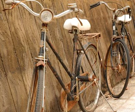 Image of two old bicycles on a brown plaster background. Stock Photos