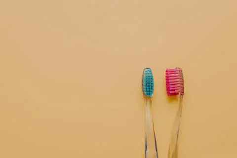 Image of two plastic toothbrushes for your hygiene against yellow background  Stock Photos