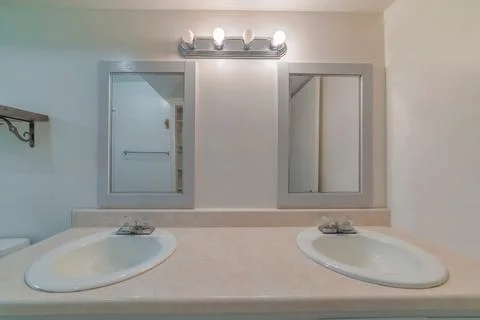 Image of two sinks, square mirrors with grey frames. Stock Photos