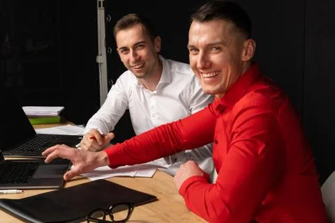 Image of two young businessmen using laptop at meeting Stock Photos