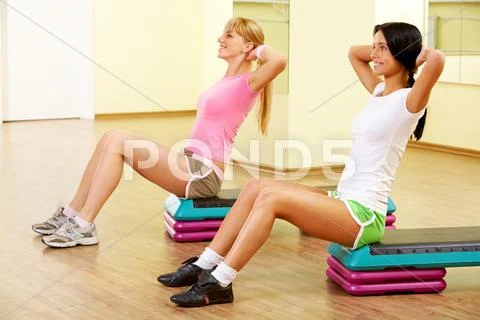 Image of two young women practicing physical exercises Stock Photos