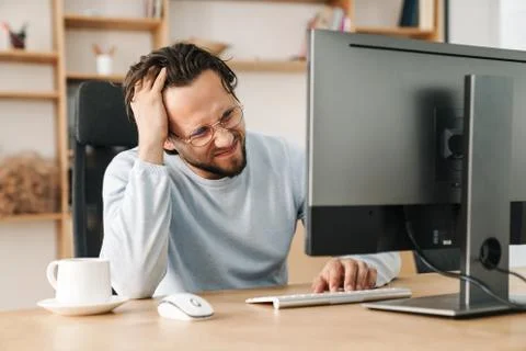 Image of unhappy bearded programmer man working with computer Stock Photos