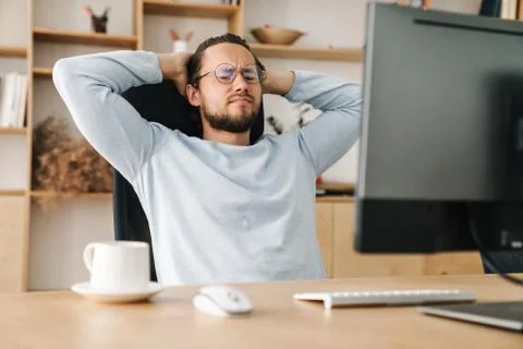 Image of unhappy bearded programmer man working with computer Stock Photos