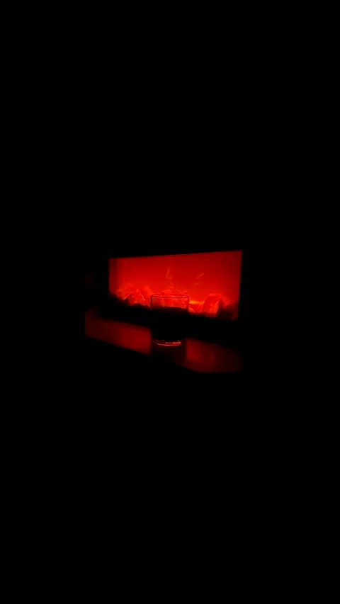 An image of a whiskey glass in front of a fireplace creates a cozy and warm Video stock 280799487